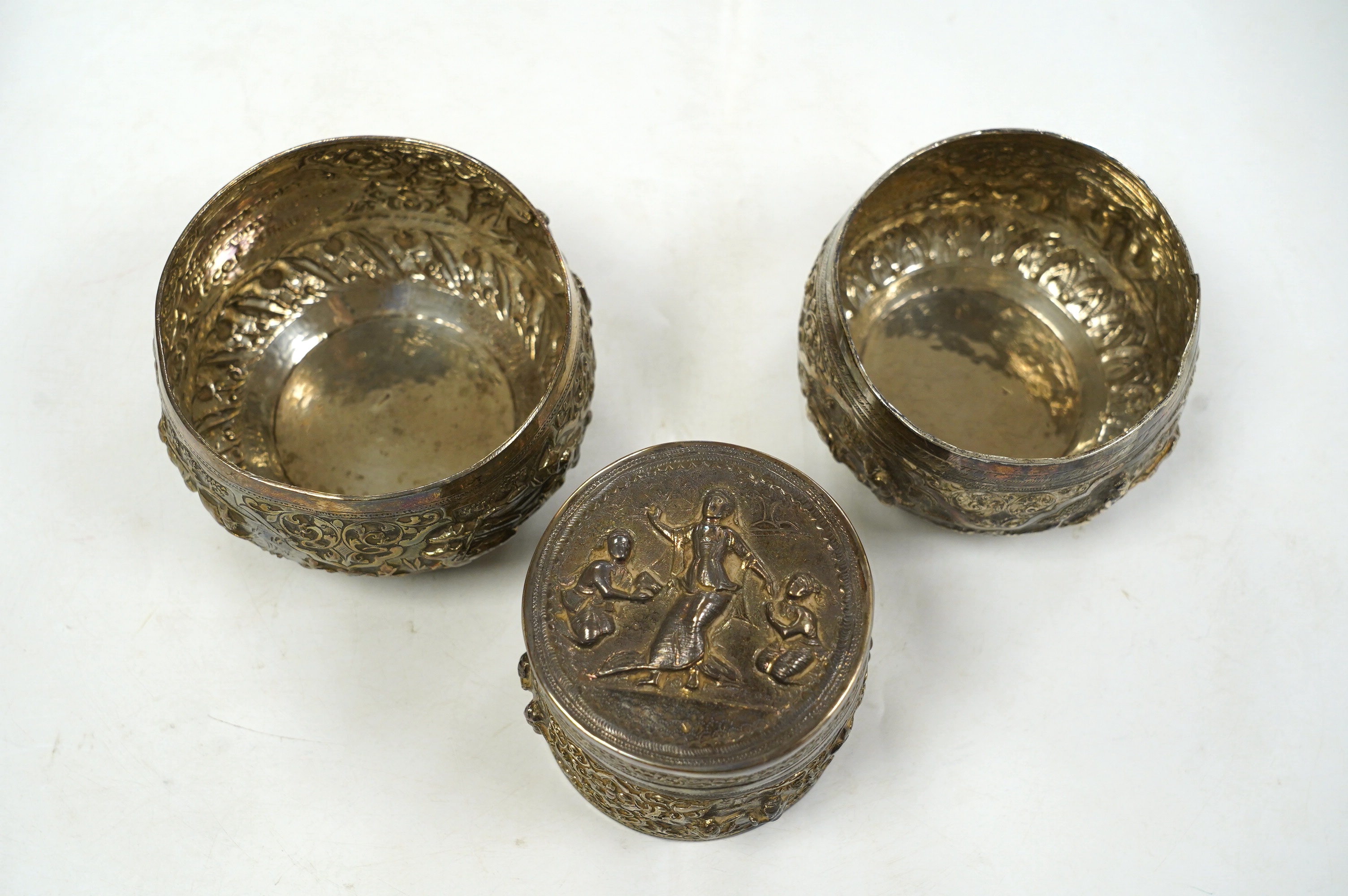 A pair of mid 20th century Indian embossed white metal small bowls, inscribed ' Agri-Horticultural Society Flower Show February 1953', diameter 10.4cm, together with a similar box and cover. Condition - poor to fair